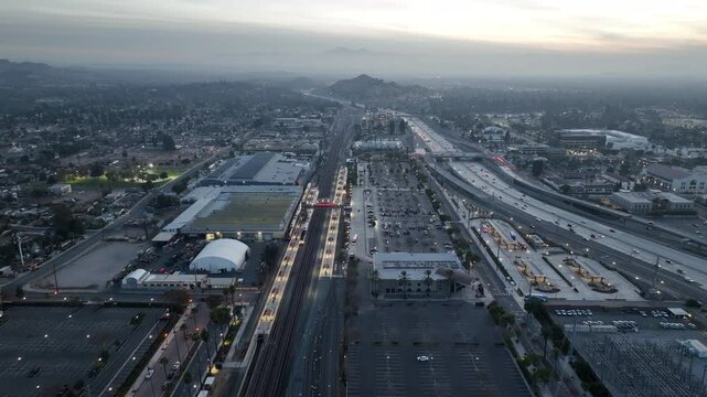 Riverside, California, USA - December 31, 204: A train pulls into the Downtown Train Station and traffic passes on the 91 freeway.