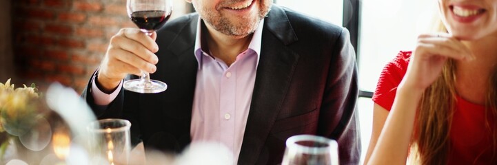 Man enjoy wine at dinner party, smiling, holding wine glass. Elegant dinner party with wine, friends, and conversation. Happy man with wine glass celebrate dinner party. Wine and dining atmosphere