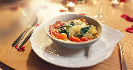 Utensils, food and meal with pasta, bowl and rose petals with candlelight, nutrition and Valentines day. Empty, table and plate with celebration for anniversary, evening and night with fine dining