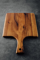 Rustic Wooden Cutting Board on Dark Surface for Culinary and Kitchen Use