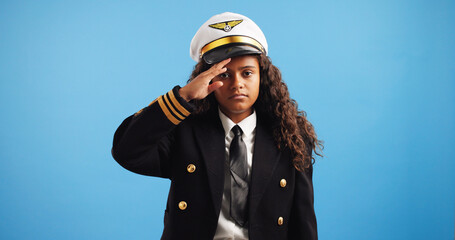 Pilot, salute and girl with portrait, uniform and confidence on blue studio background. Face, kid...