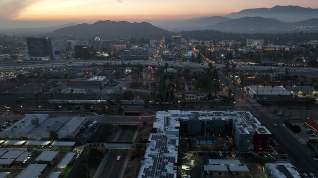 Riverside, California, USA - December 31, 204: A train pulls into the Downtown Train Station and traffic passes on the 91 freeway.