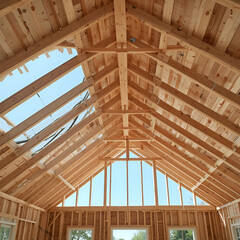Obraz premium Engineered wood joists or rafters forming the roof of a house under construction
