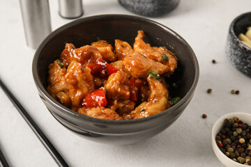 Tasty sweet and sour chicken in bowl with spices on white background, closeup