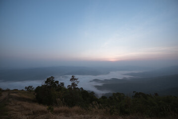 A viewpoint on a high mountain peak with morning fog.