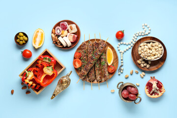 Traditional Eastern dishes, Aladdin lamp and prayer beads on blue background. Ramadan celebration