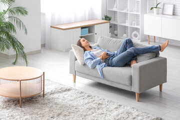 Young pretty woman lying on couch at home