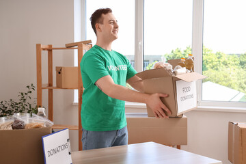 Male volunteer with food donations in center