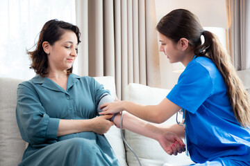 Caregiver caucasian young nurse woman measuring blood pressure with patient for checkup pulse...