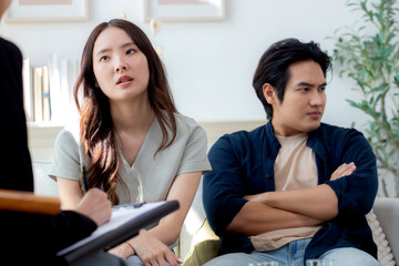 Young asian couple unhappy and conflict during psychotherapy with psychologist together,...