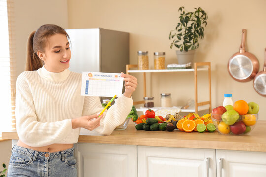 Young woman with weekly meal planer and healthy food in kitchen. Diet concept