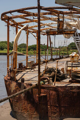 restos de embarcación oxidada y abandonada a la orilla del río que desemboca al mar
