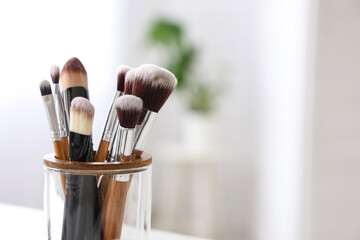 Holder with makeup brushes at home, closeup