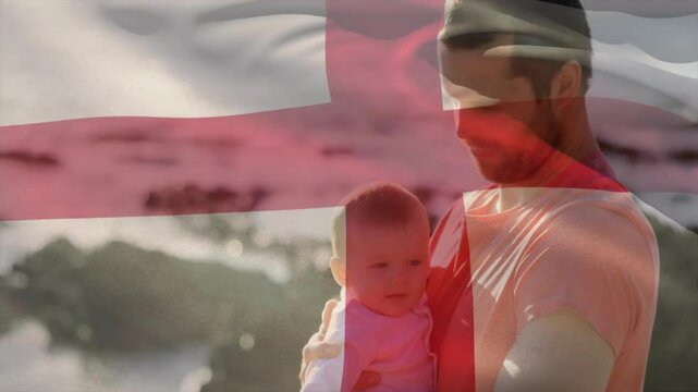 Holding baby with Danish flag animation overlay, man standing outside in park
