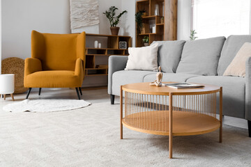 Interior of living room with grey sofa, armchair and window