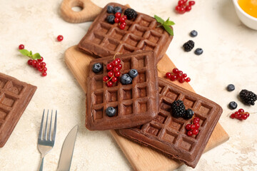 Wooden board of sweet chocolate Belgian waffles with fresh berries on white background