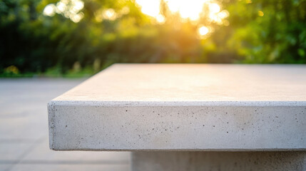 close up shot of concrete bench seat, showcasing its smooth surface and texture, illuminated by warm sunlight in serene outdoor setting. image evokes sense of tranquility and modern design