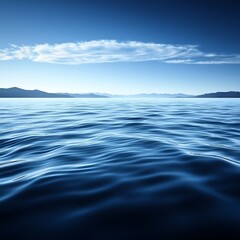 Obraz premium Clear blue ocean water with distant mountains under the sky