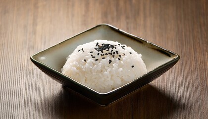 Steamed Rice with Sesame Seeds: A mound of fluffy steamed rice, sprinkled with sesame seeds, sits elegantly in a small square bowl on a wooden surface. 