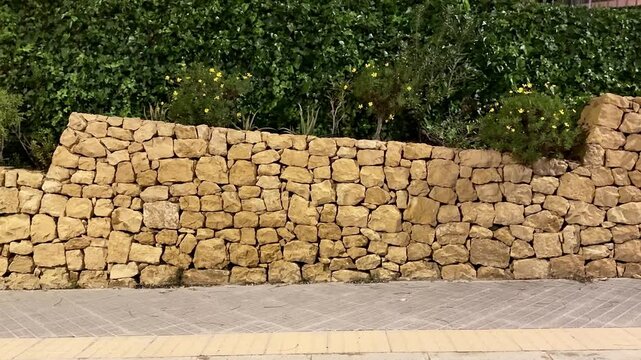 A scenic night view of a historic stone wall amid lush greenery, highlighting natures beauty and tranquility