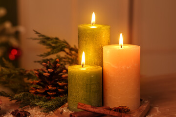 Burning candles, spices, pine cone and coniferous branch on table