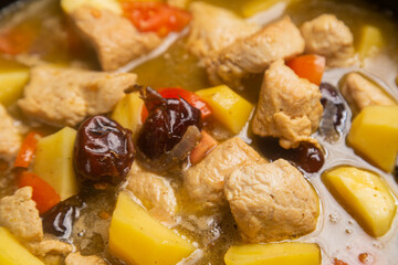 In a frying pan, chelnt is stewed with potatoes, beans, onions, meat, spices