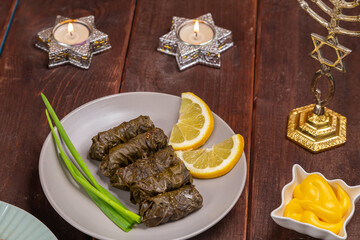 Menorah lighted candles in candlesticks with the Star of David at the set table dolma