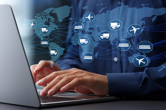 Global supply chain and logistics management. Intermodal transportation and distribution networks. Businessman using laptop computer to track freight.