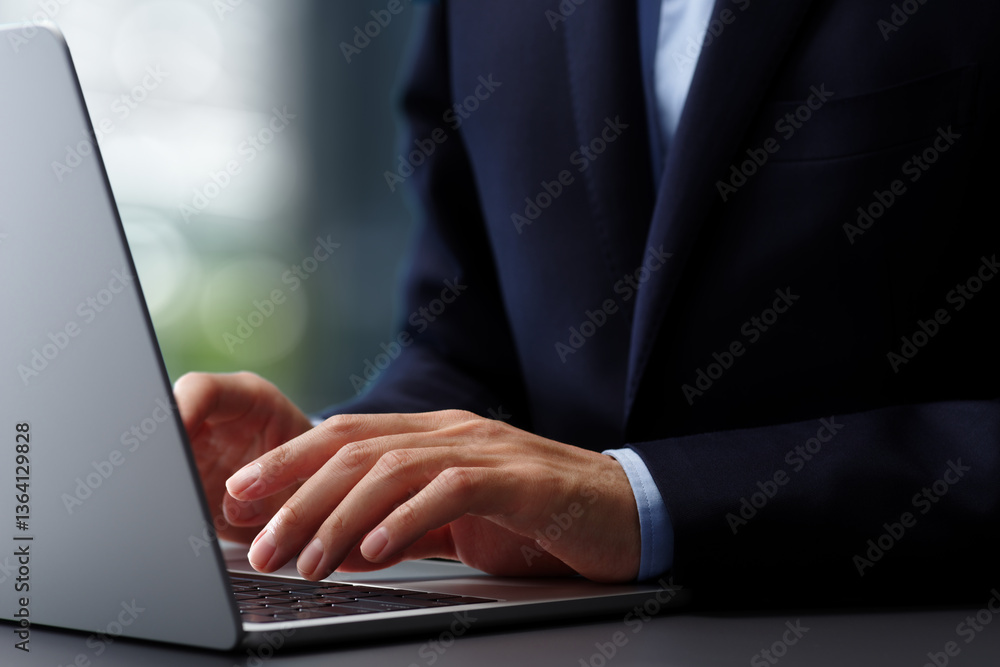 Aufkleber Hands typing on laptop computer keyboard. Businessman in suit working at desk in office. Using technologies in business.