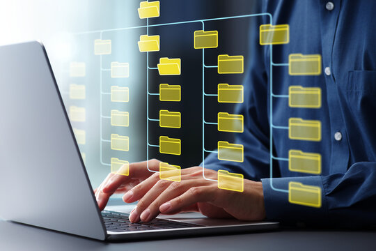 Folder hierarchy structure and document management system DMS. Businessman using laptop computer for saving and classifying files.