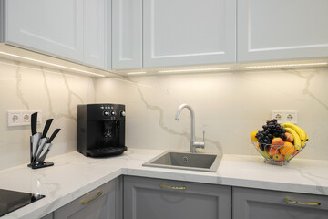 Faucet with granite sink and coffee machine in the kitchen