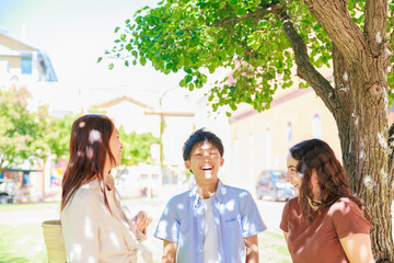 公園で談笑する大学生の男女