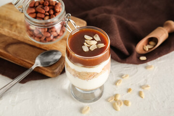 Glass with delicious peanut cheesecake on white background