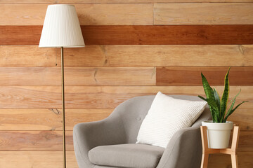 Interior of stylish living room with grey armchair, standard lamp and houseplant