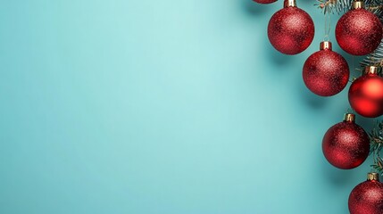 Festive red christmas ornaments hang on a branch on light blue