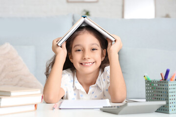 Cute girl with book doing classes at home