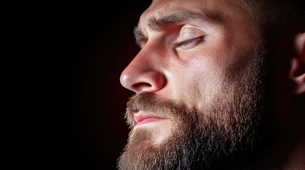Obraz premium Zbliżenie profilu mężczyzny z brodą, zamkniętymi oczami i zamyślonym wyrazem twarzy