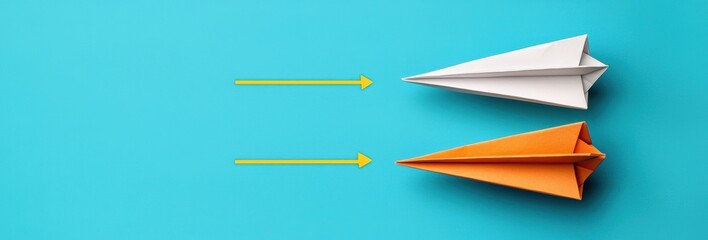 Obraz premium Two Colorful Paper Airplanes in White and Orange on a Vivid Blue Background