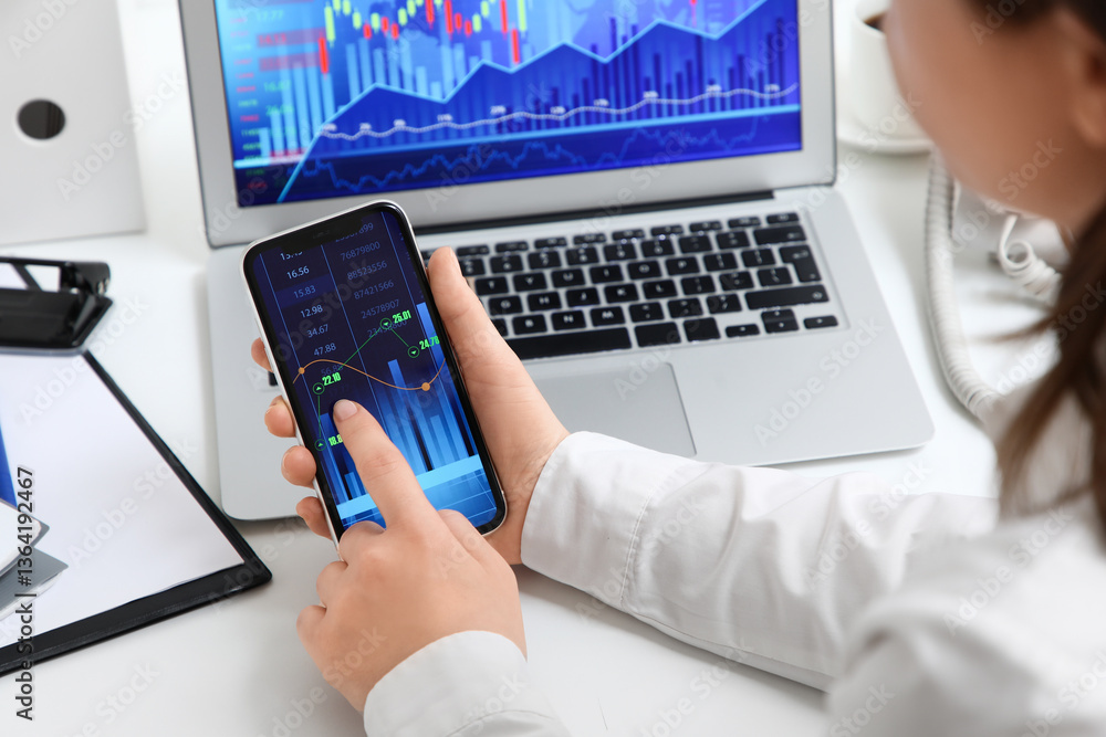 Aufkleber female trader working with mobile phone at table in office, closeup
