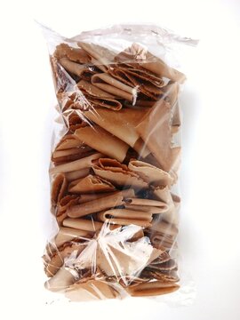 Kue semprong, Asian egg roll, sapit, sepit, kue Belanda, or kapit. Indonesian traditional wafer snack made by clasping egg batter using an iron mold.