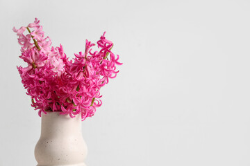 Vase with bouquet of beautiful pink hyacinth flowers on white background