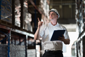 Warehouse worker, Male worker at warehouse, Storage, Check stock. Male warehouse worker checks stock inventory. Male worker holding digital tablet and checking barcodes on boxes on shelf pallet