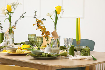 Table setting with spring flowers in light room