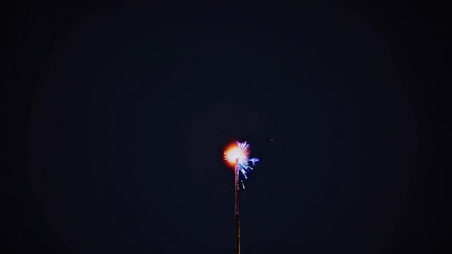 A low-angle video shot of a single sparkler against a dark sky, capturing its bright, dynamic sparks in a minimalist, celebratory style. Live desktop wallpaper.