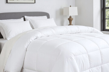 white comforter on top of a bed in a bedroom