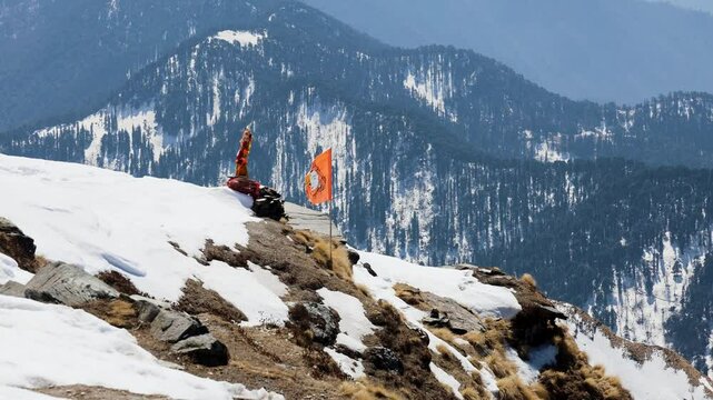 snowcap mountain peak with holy hindu flag waving at temple at morning