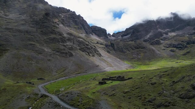 Aerial descends through cloud to old stone walls in El Choro mtn pass