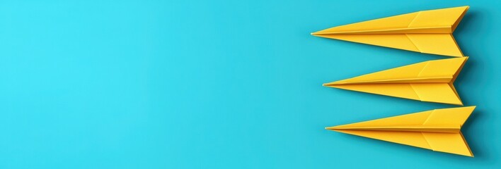 Three Bright Yellow Paper Airplanes on a Solid Blue Background Evoking Freedom and Imagination