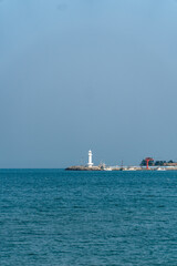 Minimalist Coastal Scene with White Lighthouse and Blue Sea