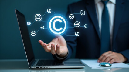 Flat Hand holding holographic copyright symbol with legal icons and magnifying glass on laptop in empty space concept as Hand holds holographic copyright symbol on laptop surrounded by legal icons and